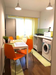 a kitchen with a table and chairs and a washing machine at New Central Roof top view in Bucharest