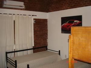 1 dormitorio con 1 cama y 1 coche rojo en la pared en Palmares Del Paso en Paso de la Patria
