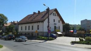 a large white building with a brown roof on a street at Pokoje Złotoryja in Złotoryja