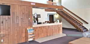 a lobby with a staircase and a bar with a tv at AmeriVu Inn & Suites-Avon in Avon
