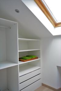 a room with white shelves and a skylight at Apartamento Vila O Valadouro in Ferreira