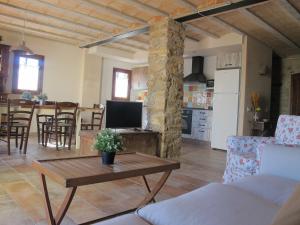 a living room with a table and a kitchen at Cal Nenot in Puigcercos