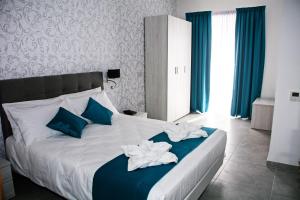 馬爾薩什洛克的住宿－漁夫的小海灣住宿加早餐旅館，一间卧室配有一张带蓝色和白色毛巾的床