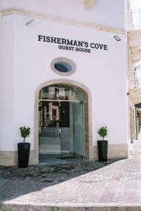 a white building with a door to a guest house at Fisherman's Cove Guesthouse in Marsaxlokk