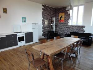 a kitchen and dining room with a wooden table and chairs at L'école buissonnière in Combrand