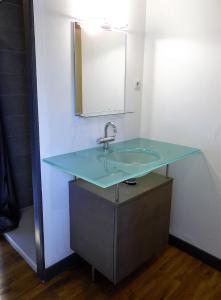 a bathroom with a blue sink and a mirror at L'école buissonnière in Combrand