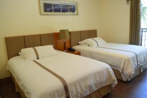 a hotel room with two beds with white sheets at Saipan Beach Hotel in Saipan