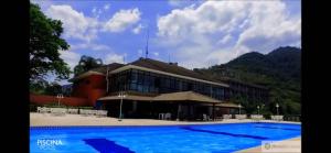 a large building with a swimming pool in front of it at Porto Real Suítes in Mangaratiba