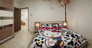 a bedroom with a cow bed and a tree on the wall at 758 Residence in Miri