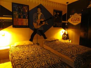 a room with two beds with a man playing a guitar at Vila Rock Hostel - próximo Allianz Parque, Vila Madalena, Av Paulista, Hospital das Clínicas INCOR FMUSP in São Paulo