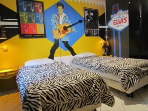 two beds in a room with a mural of a man playing a guitar at Vila Rock Hostel - próximo Allianz Parque, Vila Madalena, Av Paulista, Hospital das Clínicas INCOR FMUSP in São Paulo