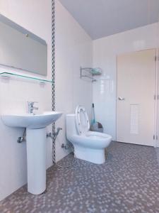 a white bathroom with a sink and a toilet at Wind Island in Magong +42 photos
