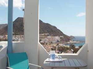 een tafel en stoelen op een balkon met uitzicht op de oceaan bij La Loma in San José