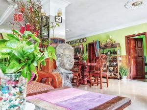 a statue in a room with a table and chairs at Ta Som Guesthouse & Tour Services in Siem Reap