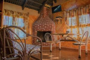 a brick fireplace in a room with a table and chairs at Cabañas los Cedros in Cuetzalán del Progreso