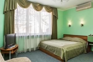 a bedroom with a bed and a television at Na Ilyinke in Nizhny Novgorod