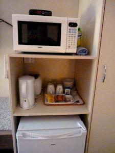 a microwave oven sitting on top of a refrigerator at International Lodge Motel in Mackay