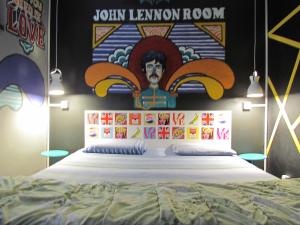 a bedroom with a bed with a painting on the wall at Vila Rock Hostel - próximo Allianz Parque, Vila Madalena, Av Paulista, Hospital das Clínicas INCOR FMUSP in São Paulo