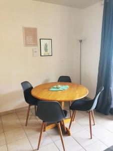 a wooden table with four chairs around it at Studio Kaoha Nui - Private apartment in Papeete