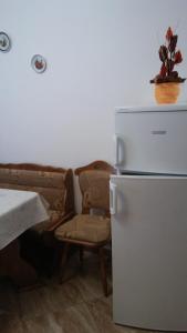 eine Küche mit einem Kühlschrank, einem Tisch und einem Sofa in der Unterkunft Márti Vendégház in Hegykő