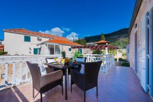 a patio with a table and chairs on a balcony at Summer Life Apartment in Slano