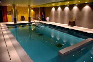 a large swimming pool in a hotel room at Domitys - Le Castel Du Val in Pérignat-lès-Sarliève