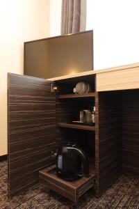a wooden cabinet with a television in a hotel room at Smile Hotel Premium Osaka Hommachi in Osaka
