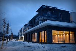 a building with large windows in the snow at Domitys - Le Castel Du Val in Pérignat-lès-Sarliève
