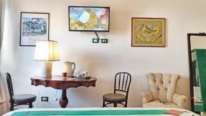 una camera da letto con tavolo, sedie e lampada di Le stanze di Bruno a Pescara