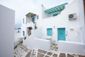 a view of a white building with a blue door at PEBBLES 1BD house with Sea View in the heart of Naousa in Naousa
