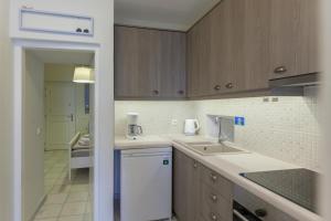 a kitchen with wooden cabinets and a white dishwasher at PEBBLES 1BD house with Sea View in the heart of Naousa in Naousa