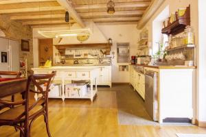 a large kitchen with white cabinets and a wooden floor at Il Giardino Di Rosmarino in Pontremoli