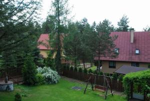 una casa con una valla y un patio con un columpio en usokoła, en Gawrych Ruda