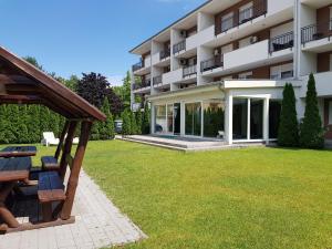 a large building with a lawn in front of it at Black Brothers Wellness Apartments in Siófok