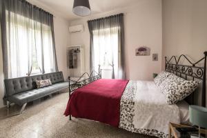 1 dormitorio con cama, sofá y ventanas en Il Giardino Di Vico Neve, en Nápoles