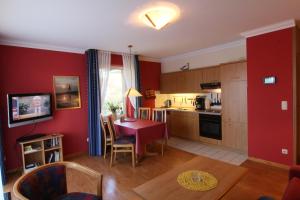 a living room with a table and a kitchen at Residenz Albatros in Cuxhaven