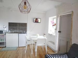 a kitchen and dining room with a white table and chairs at Les Marronniers in La Chapelle-sous-Brancion