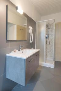 La salle de bains est pourvue d'un lavabo et d'une douche. dans l'établissement Fiori sull'Acqua Apartments, à Peschiera del Garda