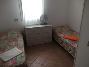 1 dormitorio con 2 camas, vestidor y ventana en Appartamento La Valle, en Marina Romea