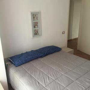 ein Schlafzimmer mit einem Bett mit einer blauen Decke darauf in der Unterkunft Appartamento La Valle in Marina Romea