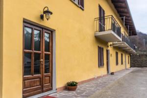 um edifício amarelo com uma porta e uma varanda em Casa in Langa em Alba