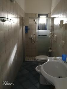 La salle de bains est pourvue d'un lavabo, de toilettes et d'une douche. dans l'établissement Bed and breakfast Delfino Blu, à Torre Vado