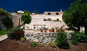 a patio with a picnic table and a stone wall at B&B Candelária in Loulé