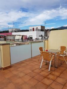 een patio met een tafel en stoelen op een dak bij Apartamentos Comfort Calella in Calella