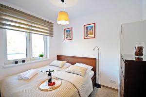a bedroom with a bed with a tray of food on it at Dwie Sosny Apartament 38 - Perła in Ustronie Morskie