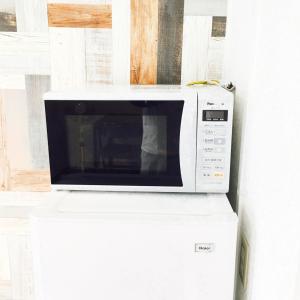 Un horno microondas colocado encima de una encimera. en Guest House Fukuoka W301, en Kasugabaru