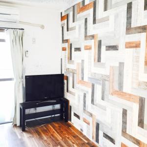 una sala de estar con una pared de madera. en Guest House Fukuoka W301, en Kasugabaru