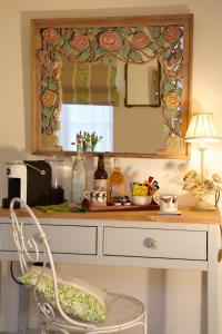 a desk with a mirror and a chair in a room at The Coach House in Rudgwick