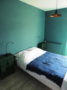 ein blaues Schlafzimmer mit einem Bett und zwei Nachttischen in der Unterkunft Domaine Houillon in Faucon