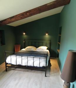 a bedroom with a bed in a green wall at Domaine Houillon in Faucon